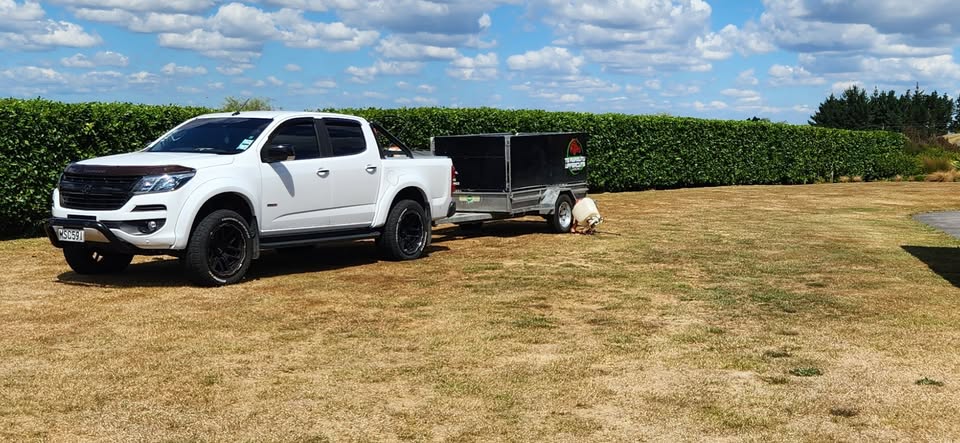 The Te Awamutu Uppercuts ute and trailer on a freshly cared-for lawn under a wide Waikato sky