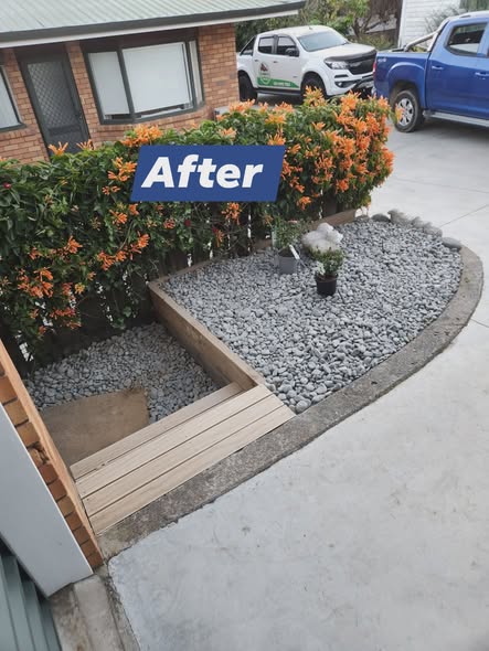 Finished landscaping with new timber edging, grey stone and tidy planting